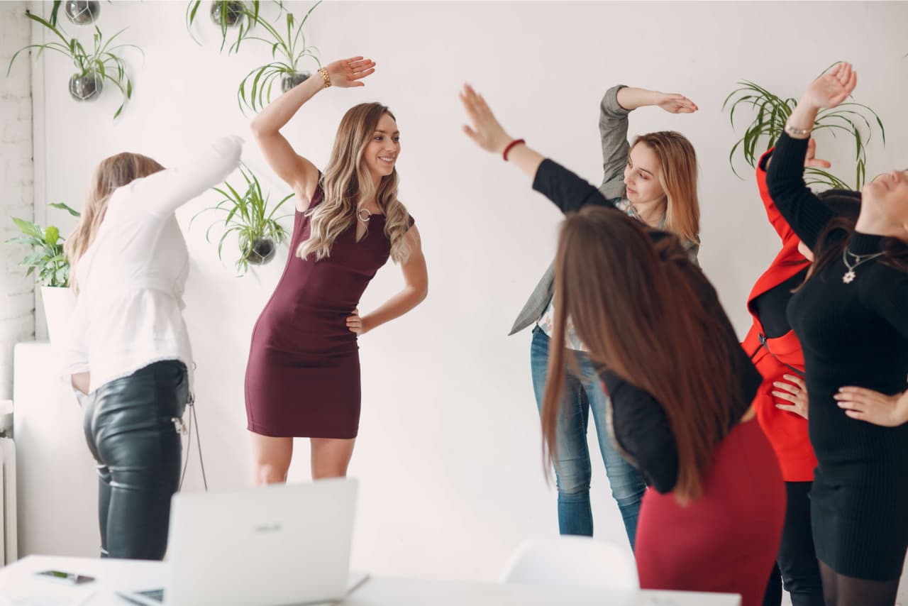 team of women doing exercises in office